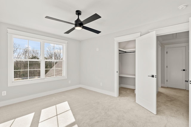 unfurnished bedroom with ceiling fan, light carpet, baseboards, a spacious closet, and a closet