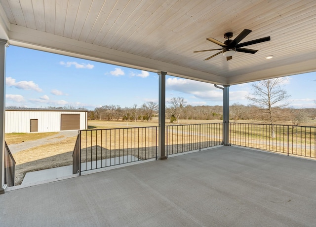 view of patio / terrace featuring a garage and a ceiling fan