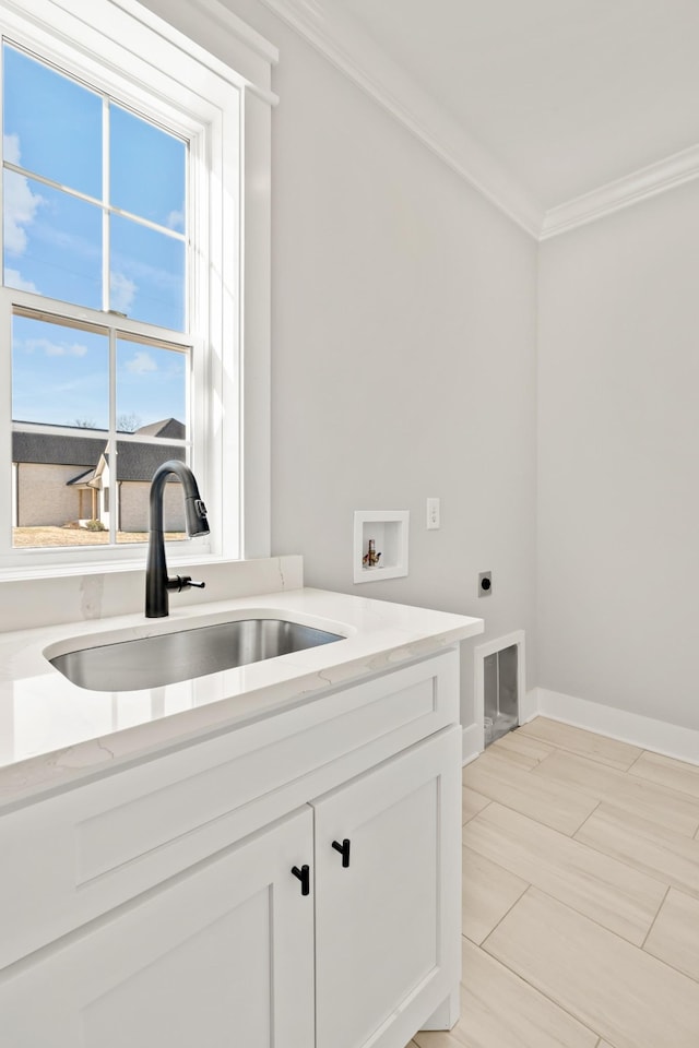 laundry room featuring baseboards, hookup for an electric dryer, crown molding, washer hookup, and a sink