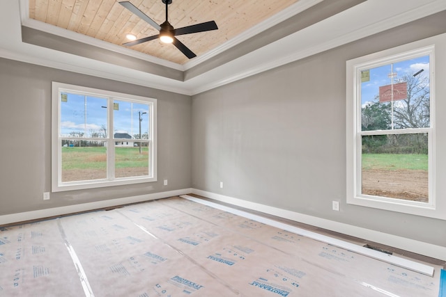 empty room featuring ornamental molding, wooden ceiling, plenty of natural light, and a raised ceiling