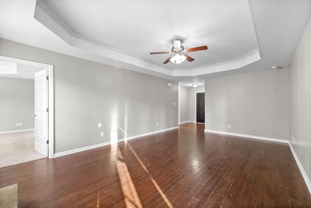 spare room with ornamental molding, dark hardwood / wood-style floors, ceiling fan, and a tray ceiling