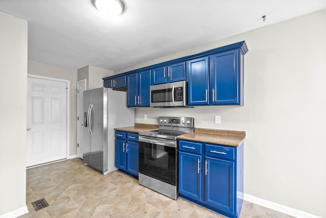 kitchen featuring blue cabinets, a textured ceiling, and appliances with stainless steel finishes