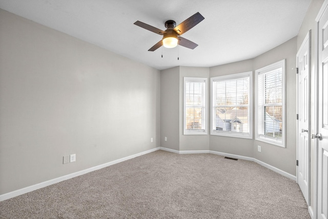 empty room with ceiling fan and light colored carpet