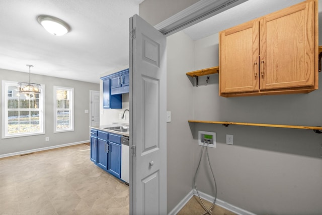 kitchen featuring blue cabinetry, decorative light fixtures, dishwasher, and sink