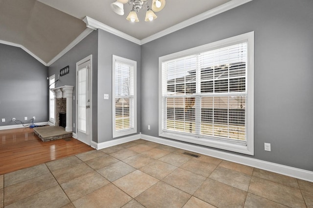 tiled foyer featuring lofted ceiling and ornamental molding