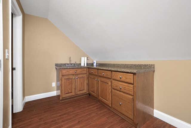 bar with sink, dark hardwood / wood-style flooring, and vaulted ceiling