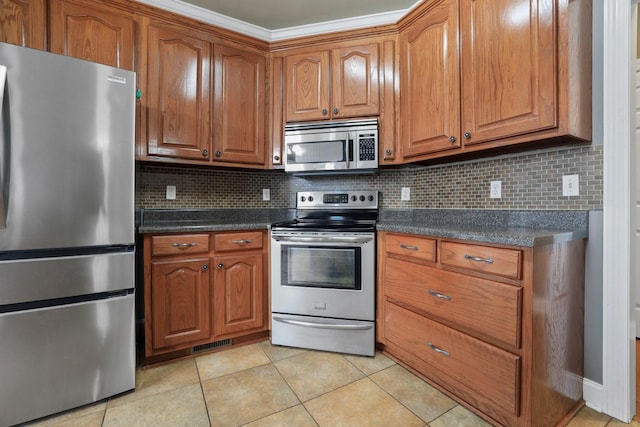 kitchen with light tile patterned floors, stainless steel appliances, and tasteful backsplash