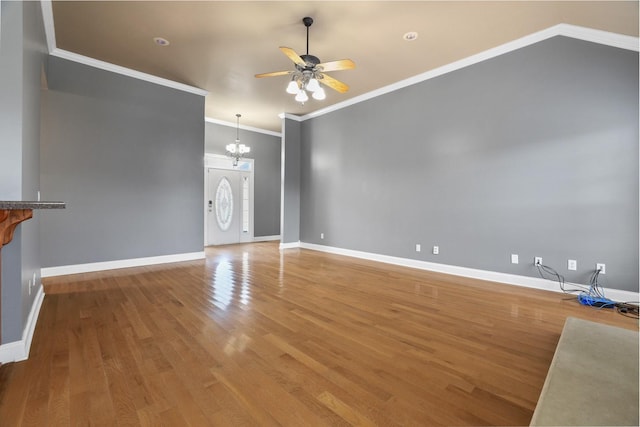 unfurnished living room with ceiling fan with notable chandelier, hardwood / wood-style floors, and ornamental molding