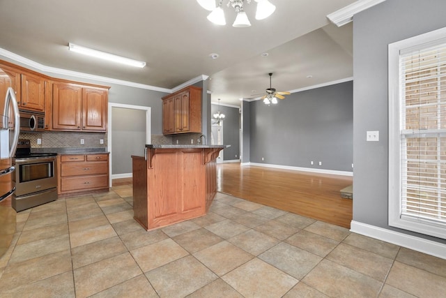 kitchen featuring a kitchen breakfast bar, kitchen peninsula, appliances with stainless steel finishes, ornamental molding, and decorative backsplash