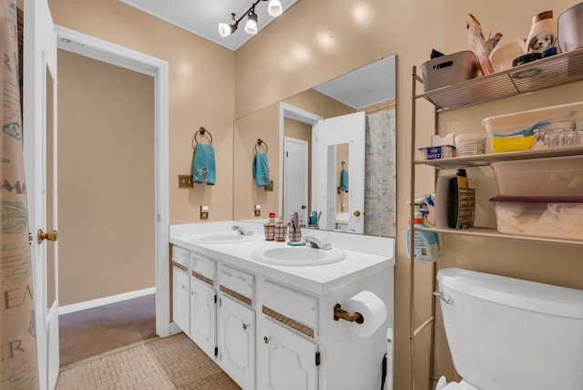 bathroom with toilet, vanity, and tile patterned flooring