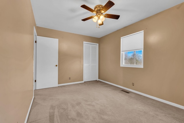 unfurnished bedroom featuring light colored carpet, a closet, and ceiling fan