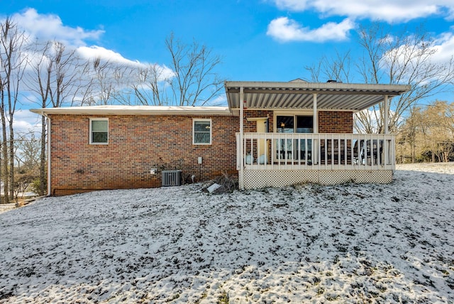 snow covered house with a wooden deck and central AC