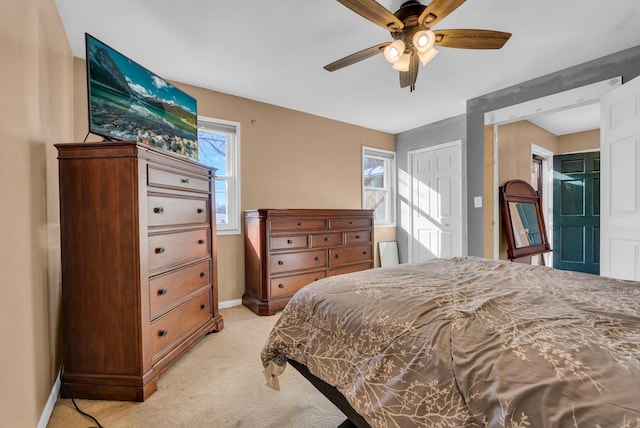 carpeted bedroom featuring multiple windows and ceiling fan