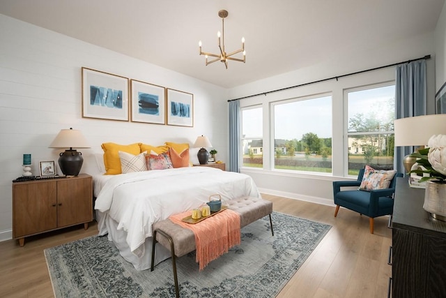 bedroom with a notable chandelier and light hardwood / wood-style floors