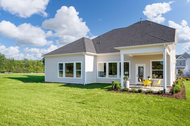 rear view of house with a patio area and a lawn