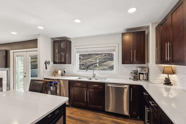 kitchen featuring tasteful backsplash, stainless steel dishwasher, dark hardwood / wood-style floors, and sink