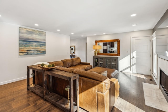 living room with a tile fireplace and wood-type flooring