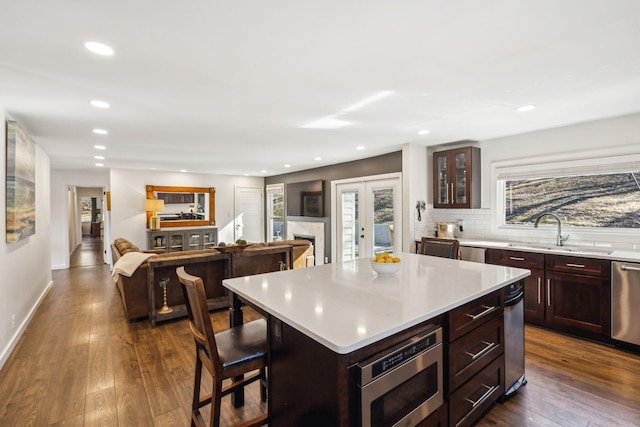 kitchen with a healthy amount of sunlight, appliances with stainless steel finishes, a center island, and sink