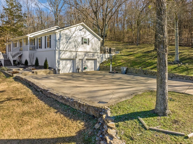 view of home's exterior with a garage, a yard, and covered porch