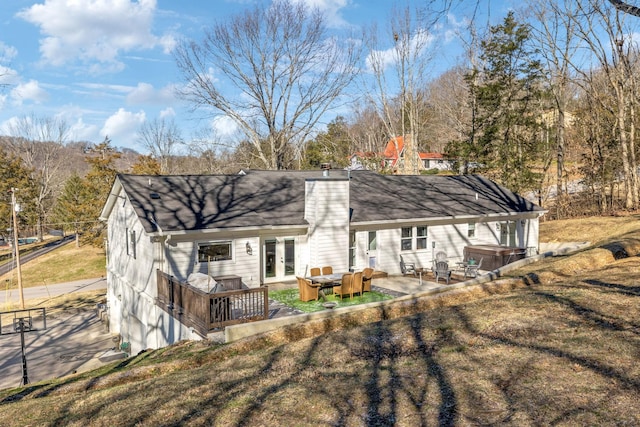 rear view of house featuring a patio area, a hot tub, french doors, and a lawn