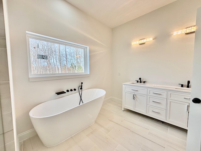 bathroom with a washtub and vanity