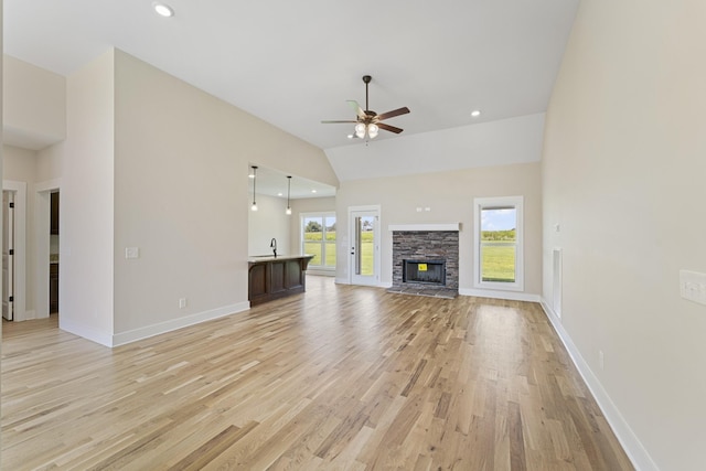 unfurnished living room featuring light wood-type flooring, plenty of natural light, and lofted ceiling