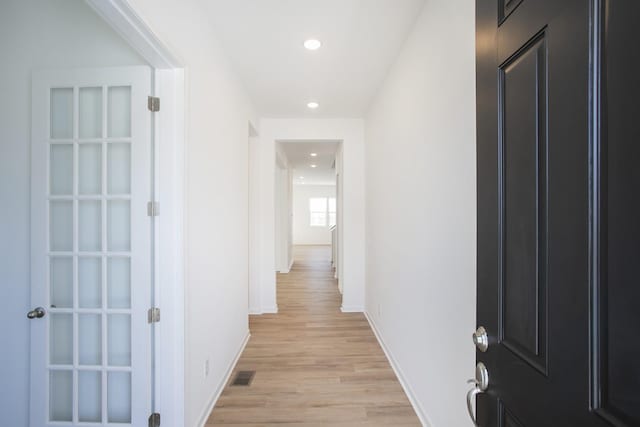 hallway with light hardwood / wood-style flooring