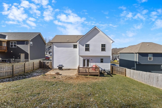 rear view of house with a lawn and a wooden deck