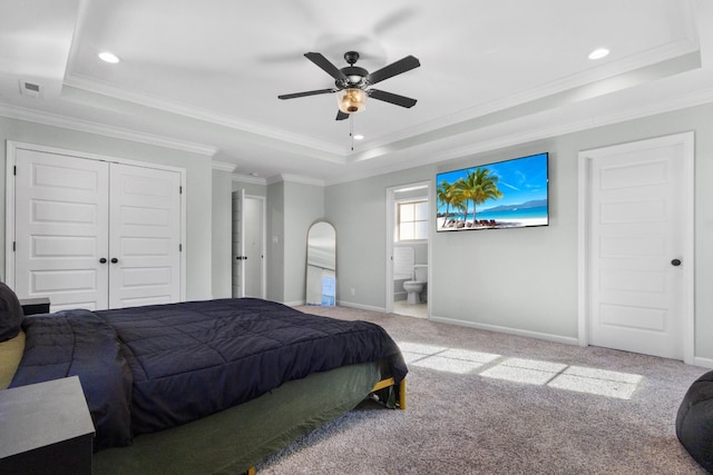 carpeted bedroom featuring connected bathroom, ceiling fan, a raised ceiling, and ornamental molding