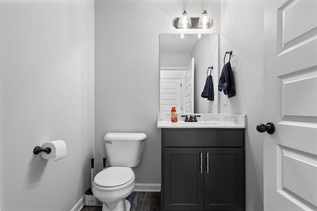 bathroom with wood-type flooring, toilet, and vanity