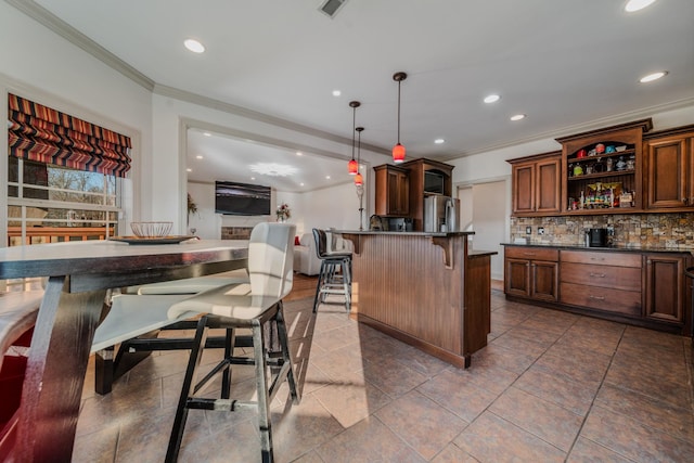 kitchen featuring stainless steel refrigerator with ice dispenser, pendant lighting, a breakfast bar, ornamental molding, and decorative backsplash