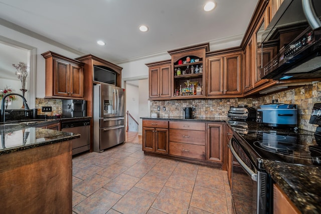 kitchen featuring crown molding, appliances with stainless steel finishes, sink, tasteful backsplash, and dark stone counters