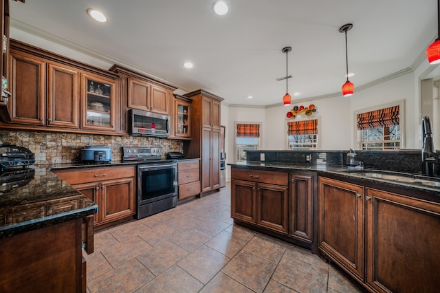 kitchen featuring sink, pendant lighting, dark stone counters, and stainless steel appliances