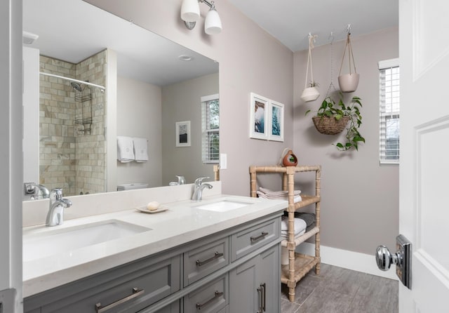 bathroom with vanity, toilet, a wealth of natural light, and a tile shower