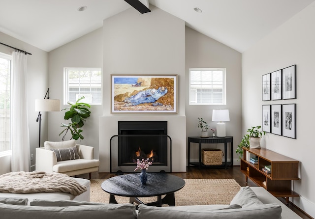 living room featuring high vaulted ceiling, dark wood-type flooring, a wealth of natural light, and beamed ceiling