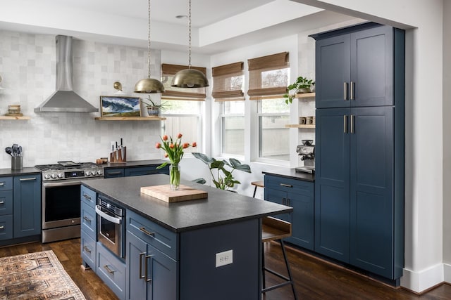 kitchen with wall chimney range hood, blue cabinets, and stainless steel gas stove