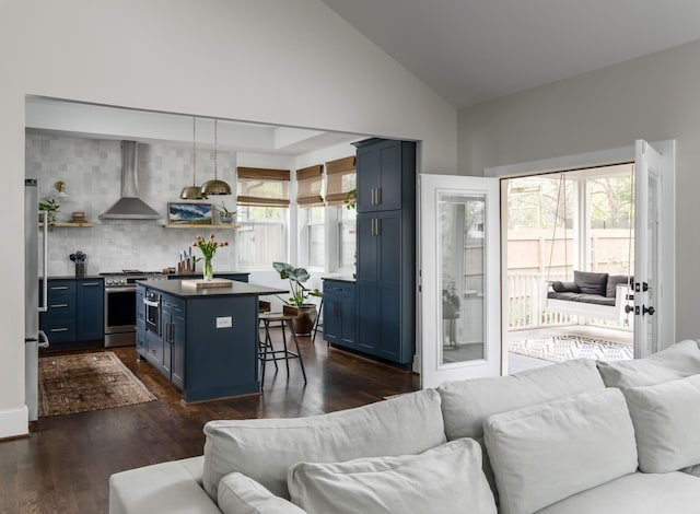 living room with plenty of natural light, dark hardwood / wood-style floors, and lofted ceiling