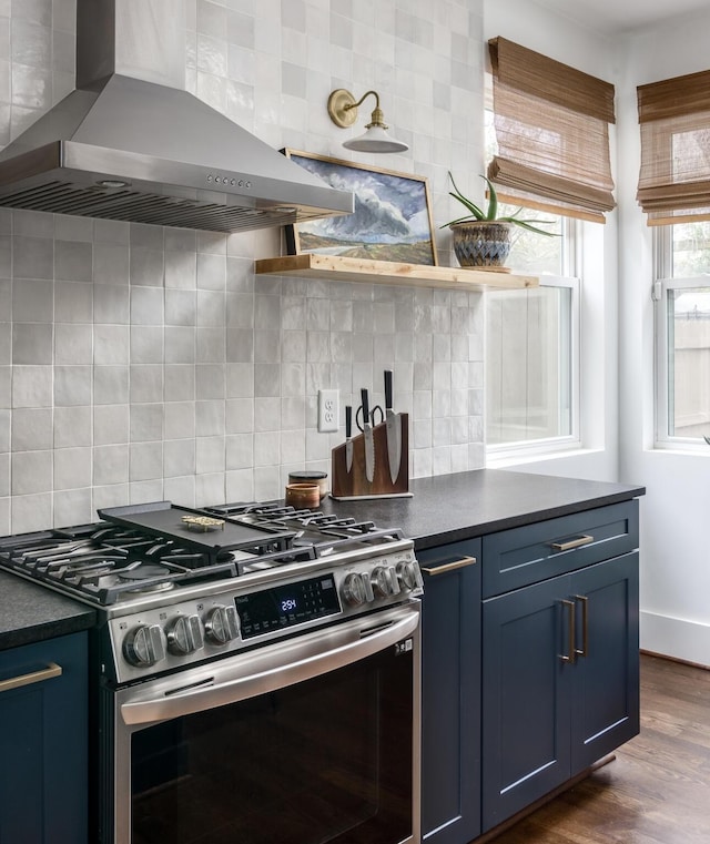 kitchen featuring backsplash, dark wood-type flooring, blue cabinets, ventilation hood, and stainless steel gas range