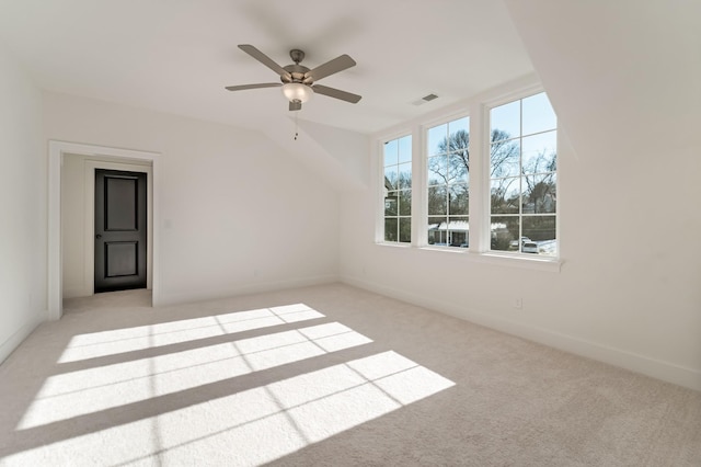 carpeted empty room featuring ceiling fan and vaulted ceiling