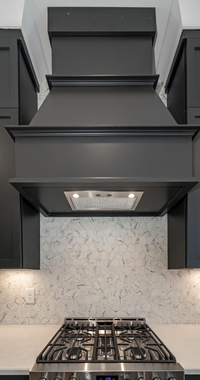 kitchen with stainless steel range oven, decorative backsplash, and gray cabinetry