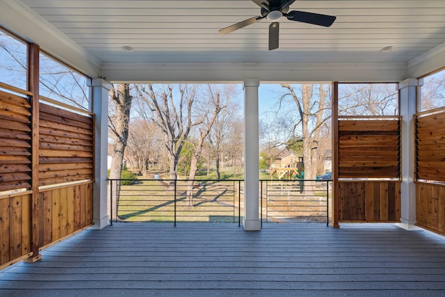 wooden deck with a playground and ceiling fan