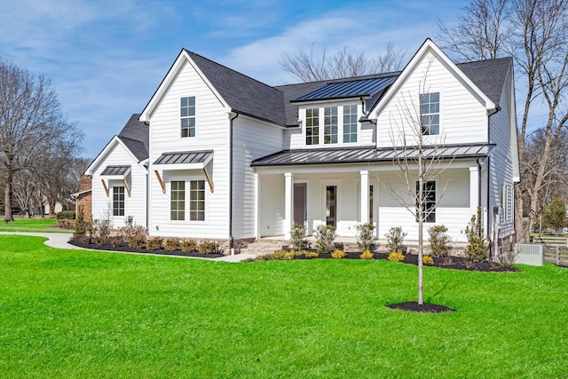 modern inspired farmhouse with covered porch and a front lawn