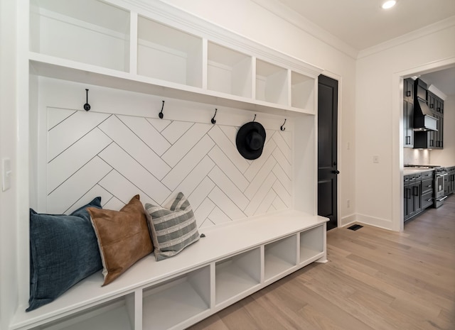 mudroom featuring crown molding and light hardwood / wood-style flooring