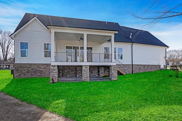 rear view of property with ceiling fan and a lawn