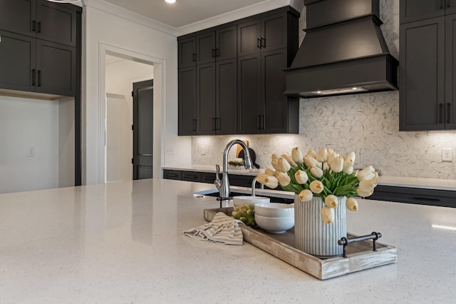 kitchen featuring crown molding, custom range hood, sink, light stone counters, and decorative backsplash