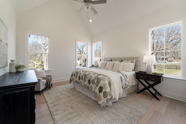 bedroom featuring light hardwood / wood-style flooring, high vaulted ceiling, and ceiling fan