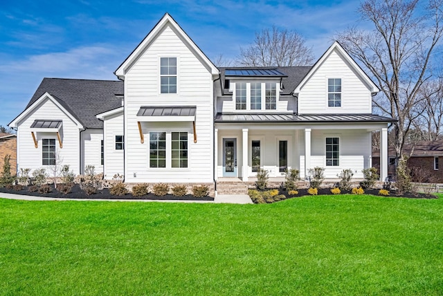 modern farmhouse featuring covered porch and a front yard