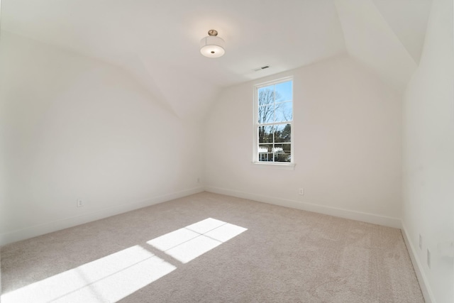 additional living space with light carpet and vaulted ceiling