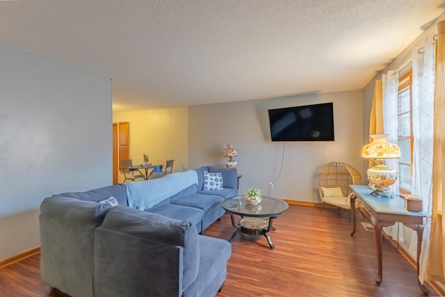 living room with wood-type flooring and a textured ceiling