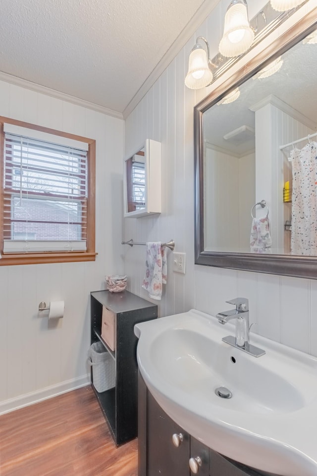 bathroom featuring vanity, crown molding, hardwood / wood-style floors, and a textured ceiling